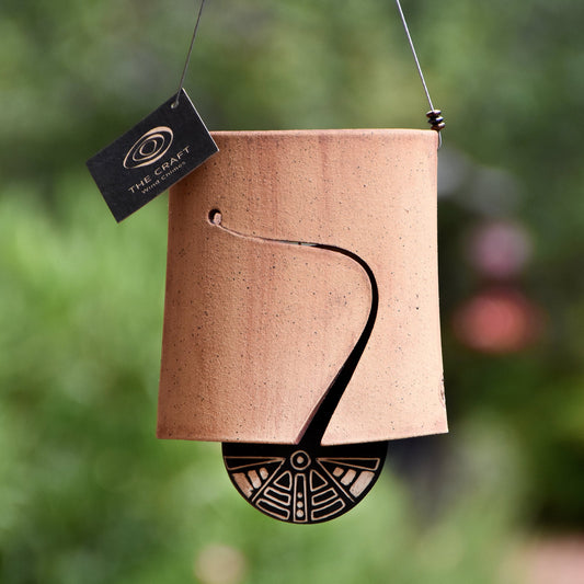 Modern, speckled buff ceramic wind chime bell that was stained with red iron oxide. The bell features a black and white sgraffito wind clapper carved with an abstract motif